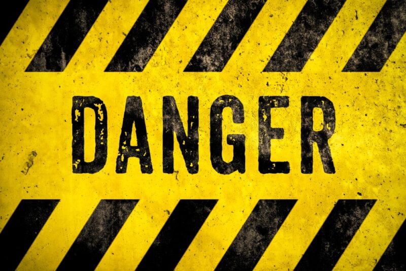DANGER warning sign word text as stencil with yellow and black stripes painted over concrete wall cement texture background. Concept image for caution, dangerous area and hazard.