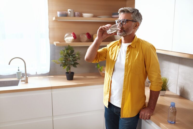 Senior Man Drinking Water. Portrait Of Mature Man With Glass Of Fresh Water