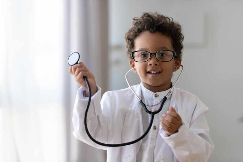 kid boy wear medical uniform glasses holding stethoscope