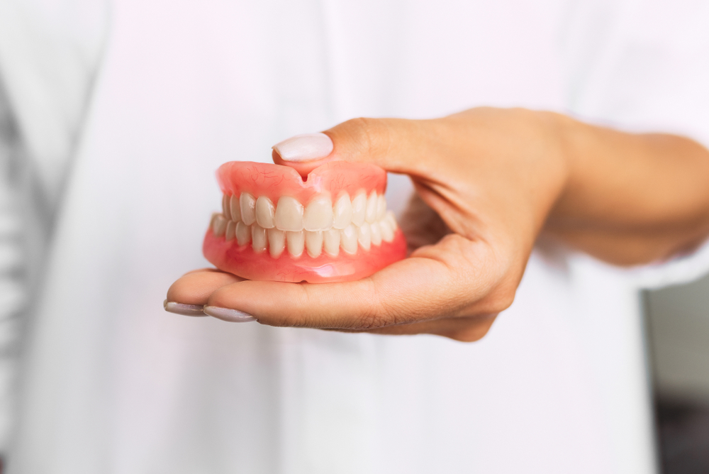 Someone holding an example of Dentures