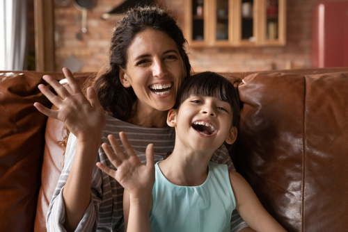 Young mom and little daughter wave