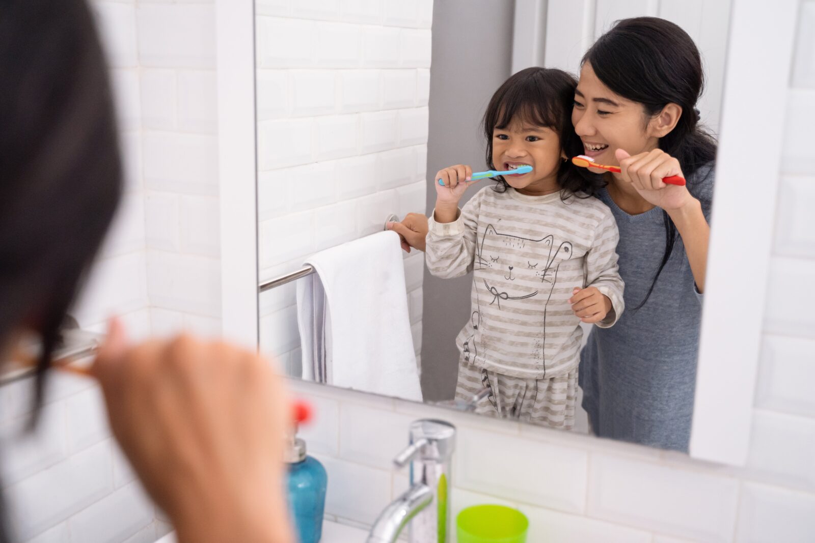mom and toddler brushing teeth together