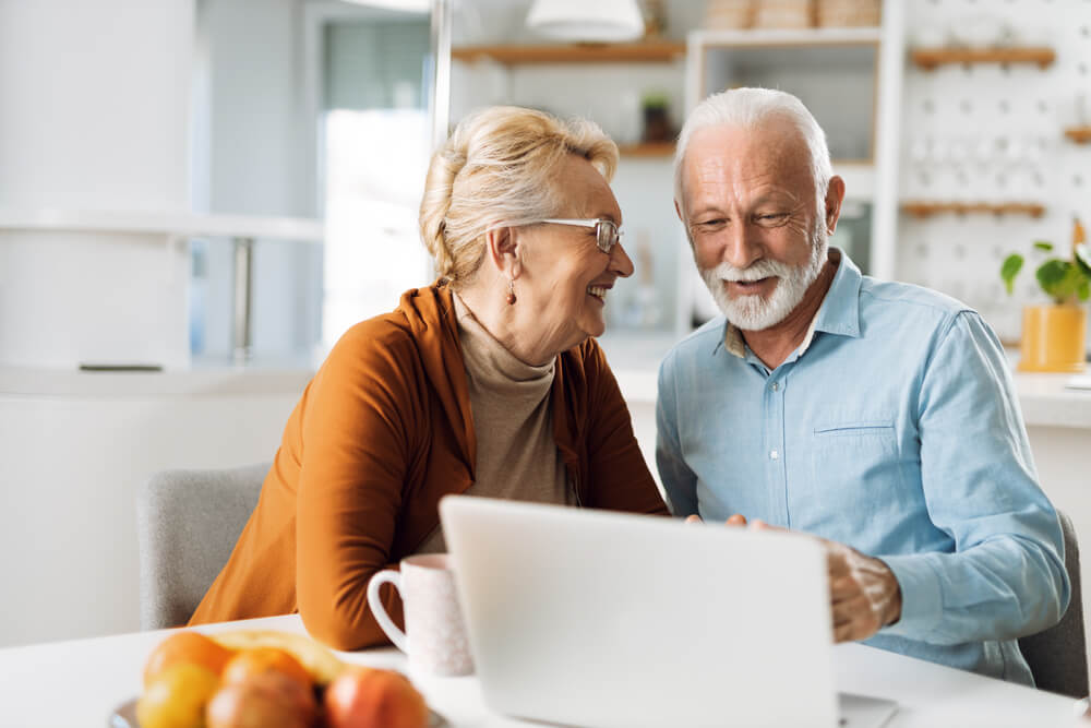 Happy mature couple using laptop