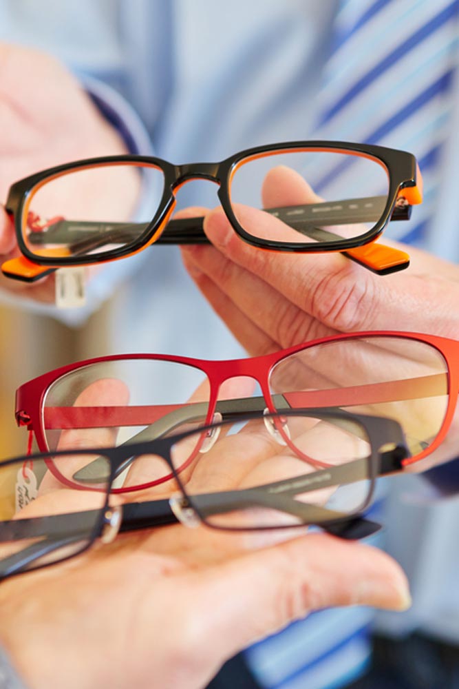 Optician offering a customer a choice of different glasses