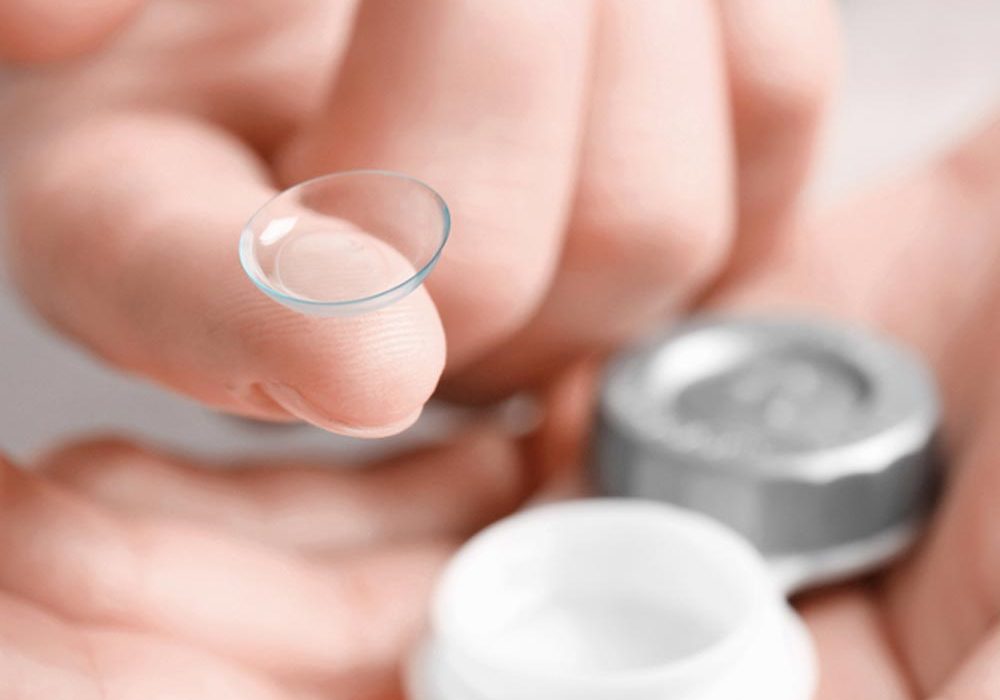 Woman holding contact lens