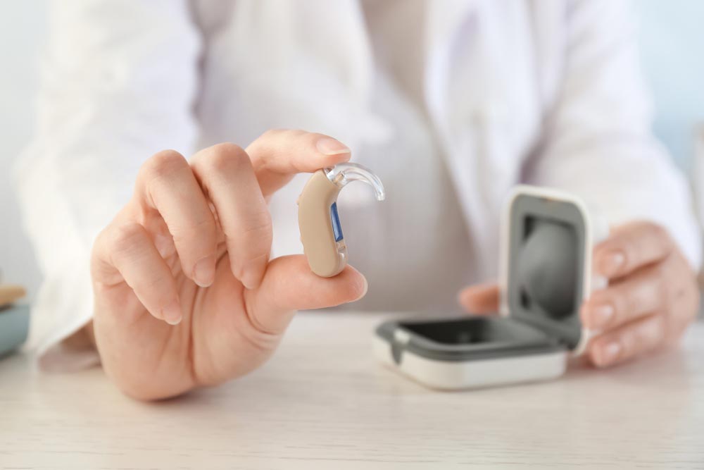 Female doctor holding hearing aid