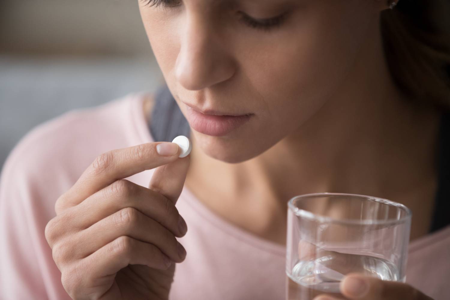 mixed race girl holding pill and glass of fresh water