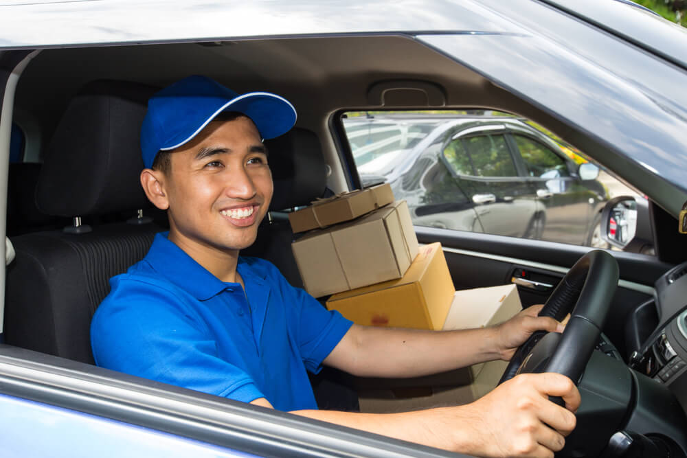 Delivery driver driving with parcels on seat