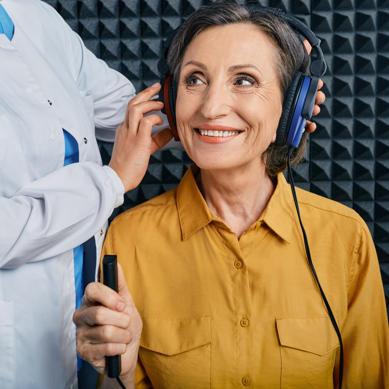 Portrait senior woman with white toothy smile while hearing check-up