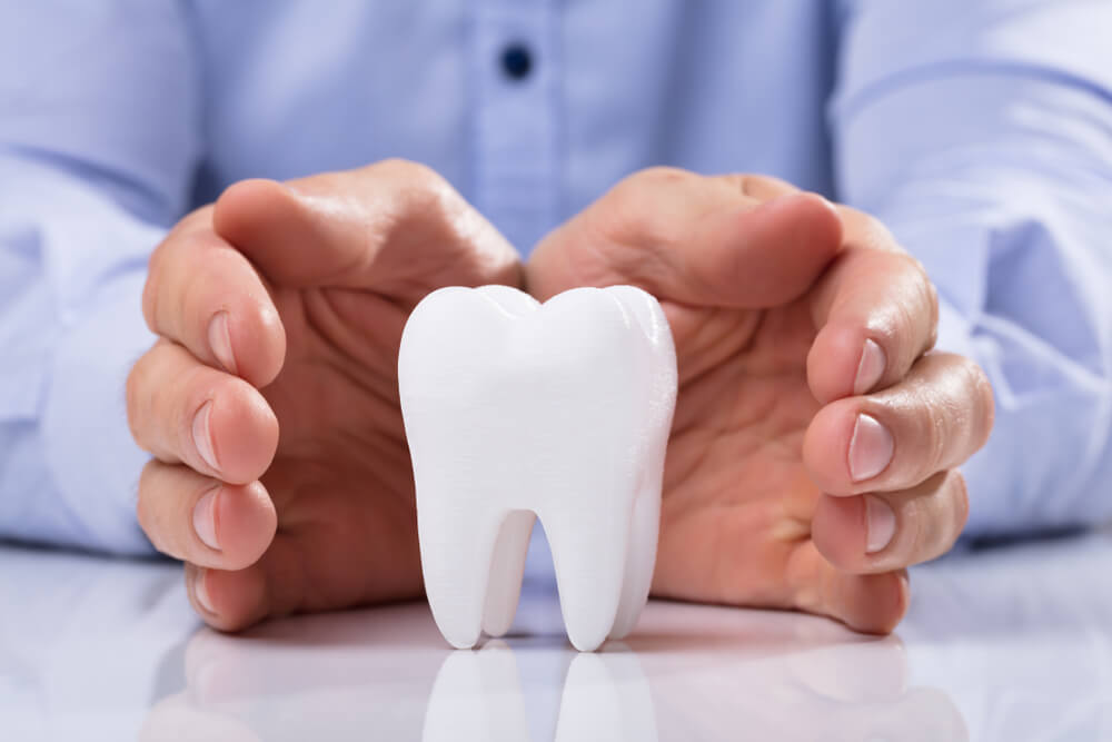 Man's Hand Protecting Healthy Hygienic White Tooth
