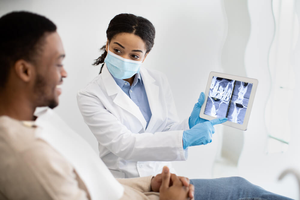 Female Dentist Showing Teeth X-ray On Digital Tablet Screen