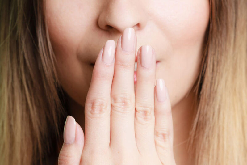 woman covering her mouth with hand