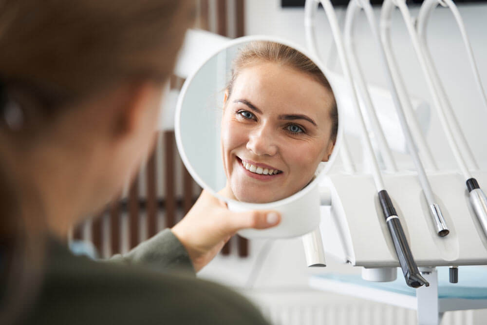 Beautiful smiling woman looking into mirror