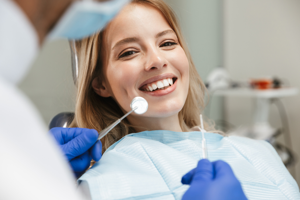 Young woman smiling on dentist chair for guarantee