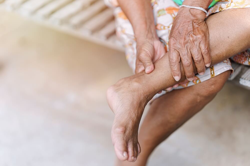 Hand of an elderly woman massaging an ankle
