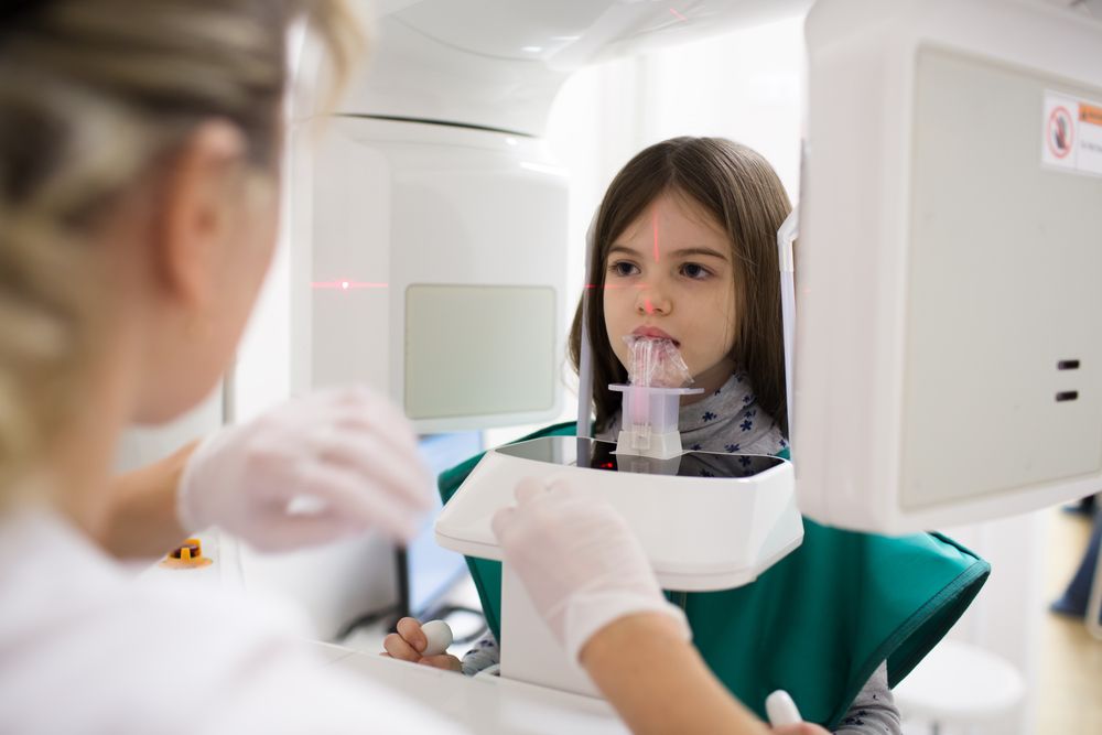 little girl patient doing panoramic teeth x-ray in dental clinic