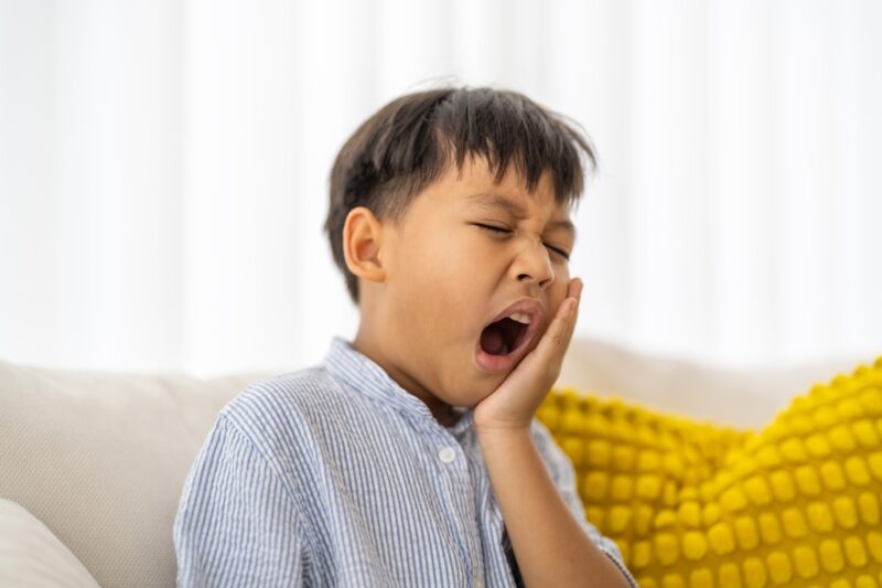 Young child experiencing toothache, tooth decay