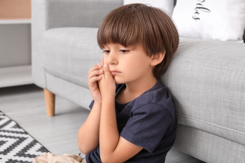 Little boy suffering from tooth ache at home