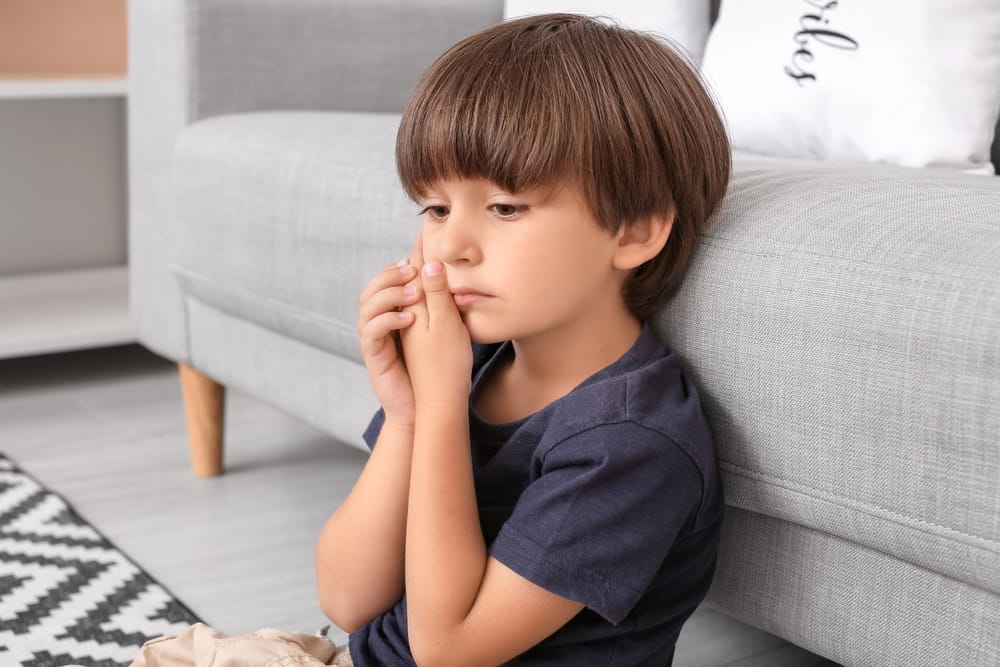 Little boy suffering from tooth ache at home