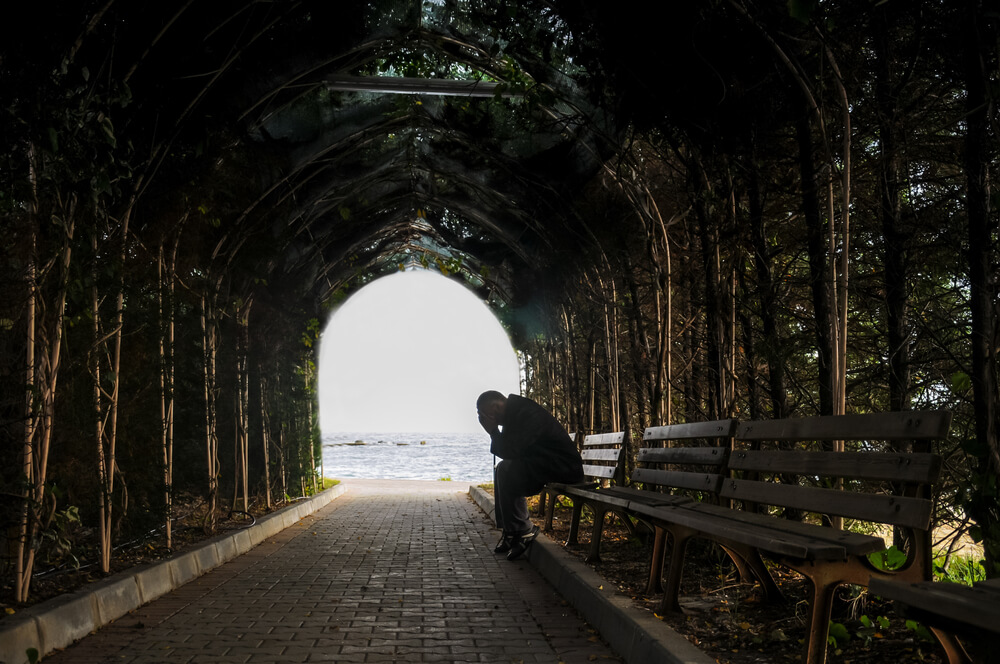 man sitting alone on the bench in the tunnel