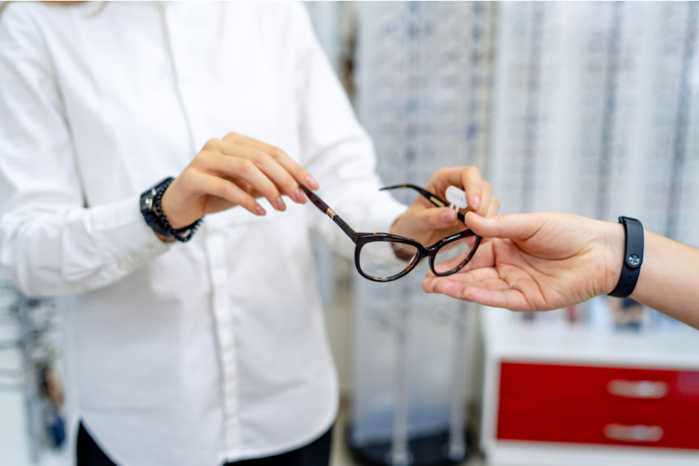 eye doctor holding glasses and specs with new lenses