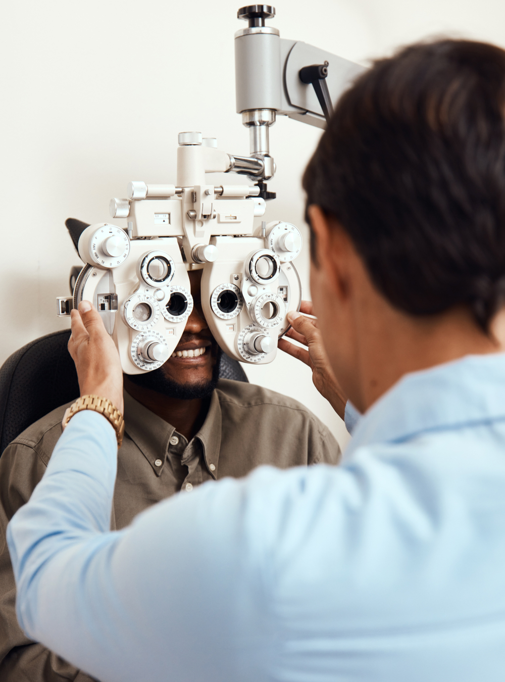 Shot of an optometrist examining her patients eyes with an optical refractor