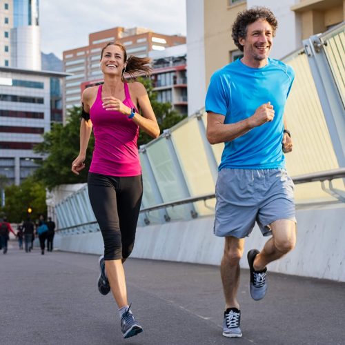Happy man and beautiful woman jogging together city bridge.