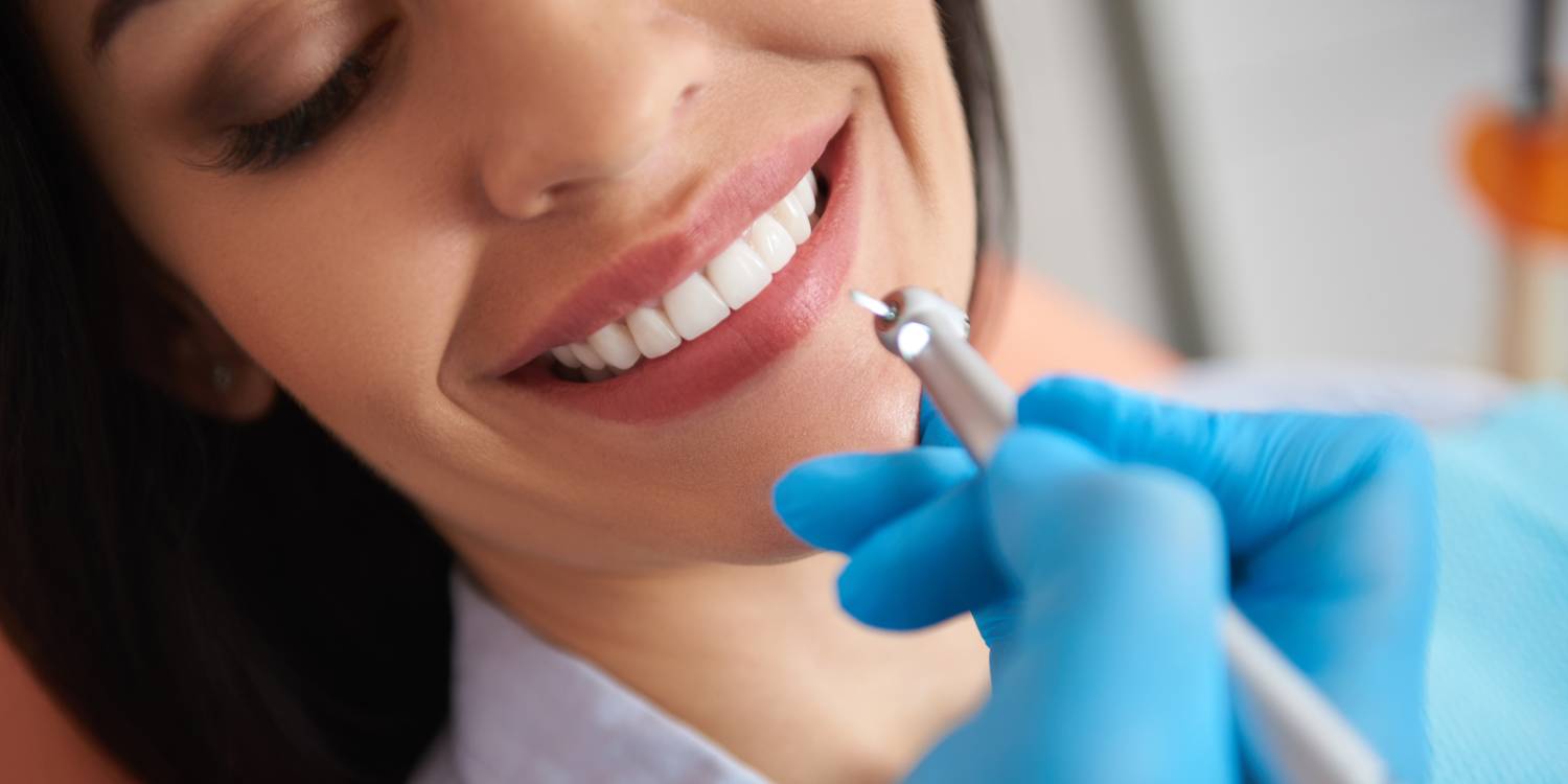Dentist in sterile gloves doing professional teeth cleaning