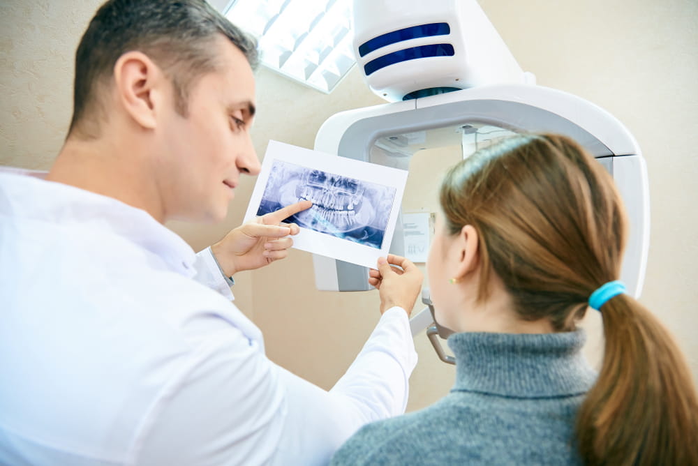 The doctor shows the patient an x-ray image.