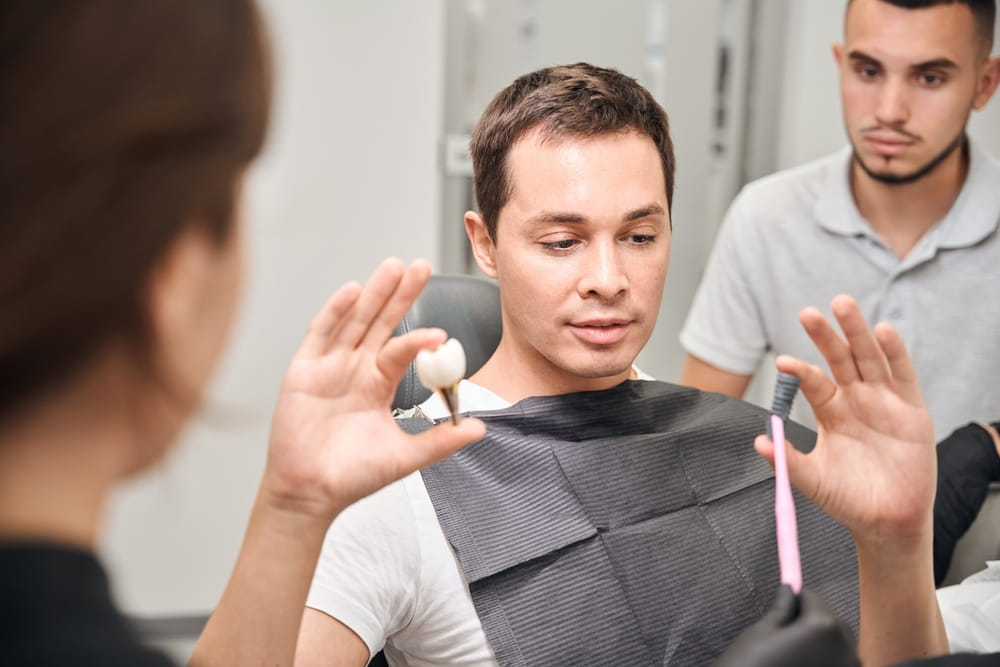 Dentists explaining process of dental implants installation to client
