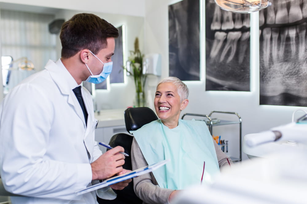 Beautiful senior woman at dentist's office satisfied after successful dental treatment.