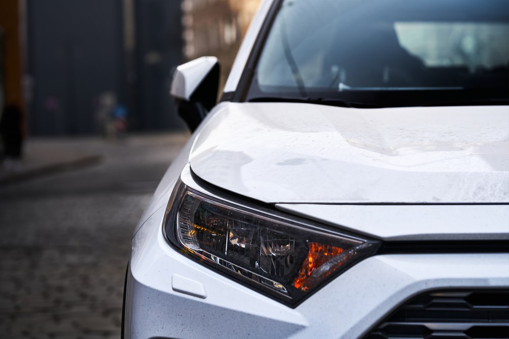 Headlights and hood of sport white car with silver stars