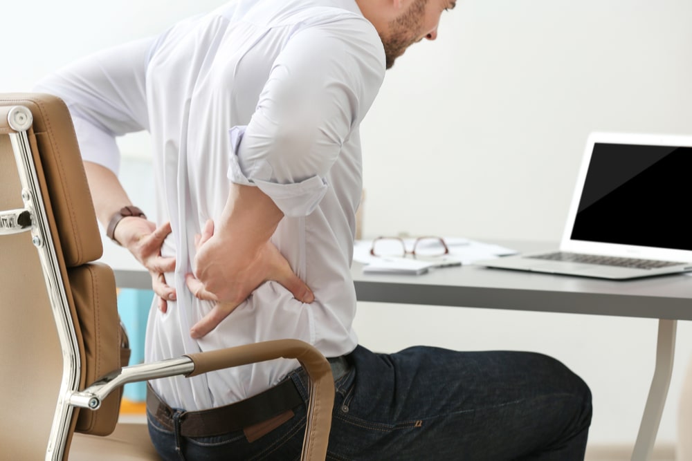 Business man with back pain in office