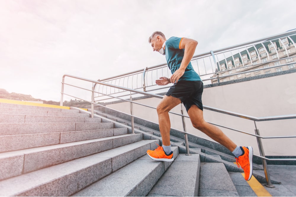 healthy lifestyle middle aged man runner running upstairs on city
