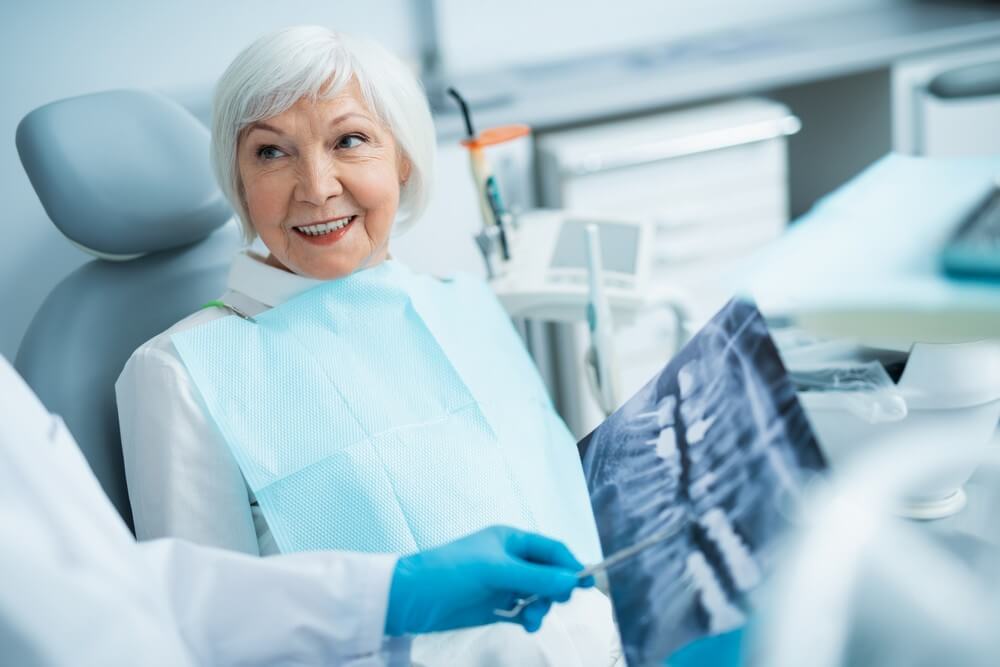 older dental patient review dental x-rays with dentist