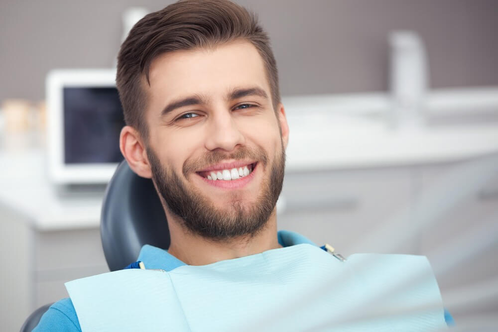 male adult smiling, anticipating a wisdom tooth removal