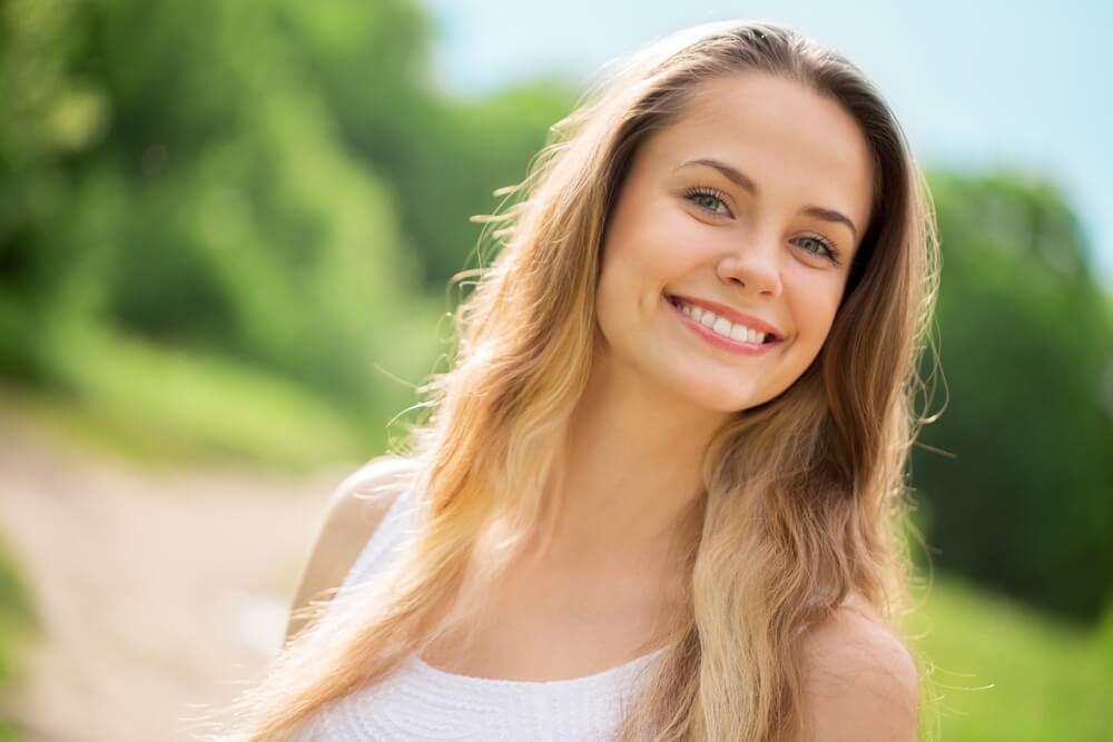 woman smiling on isolated background with a white smile after fluoride treatment